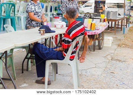 CHIANG RAI THAILAND - MARCH 20 : unidentified old asian leprosy man drinking coffee in paper cup on March 20 2016 in Chiang rai Thailand.