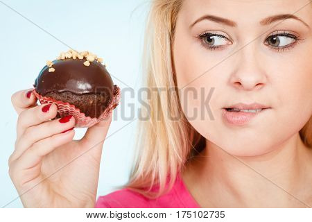Woman Holding Chocolate Cupcake About To Bite
