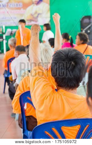 closeup old asian woman suffering from leprosy raise the hand in conference room