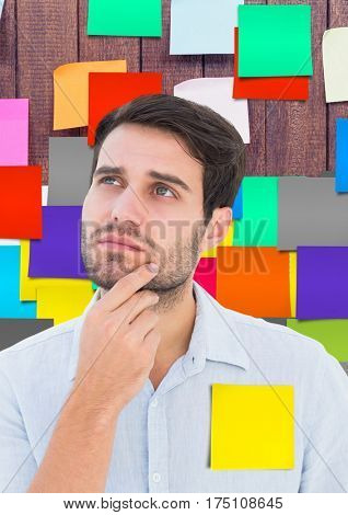 Digital composite image of thoughtful male executive standing against sticky notes