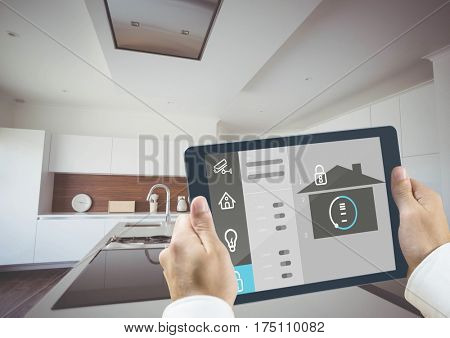 Digital composite image of hands holding digital tablet with home security icons