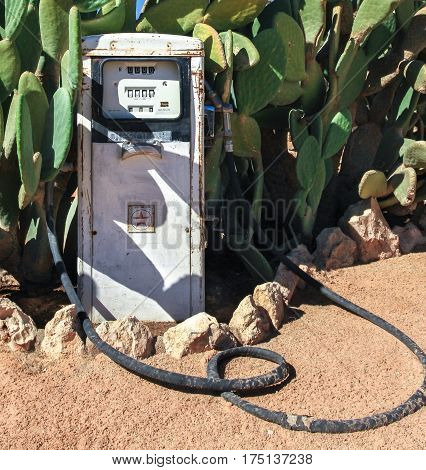 Old dirty gas station petrol pump in the desert. Overgrown by cactus. Namibia, Africa.