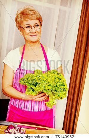 Senior woman tearing green lettuce