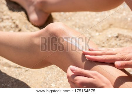 Lady applying sunscreen on leg. Hands of young woman. Get tanned on vacation. Protection for your skin.
