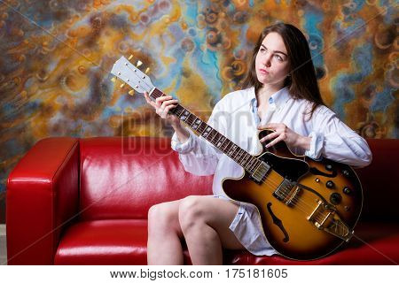 Podolsk, Russia - February 21, 2017: Young brunette girl with a vintage electric guitar Gibson es-345 1969 model year