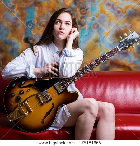 Podolsk, Russia - February 21, 2017: Young brunette girl with a vintage electric guitar Gibson es-345 1969 model year