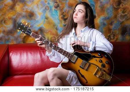 Podolsk, Russia - February 21, 2017: Young brunette girl with a vintage electric guitar Gibson es-345 1969 model year