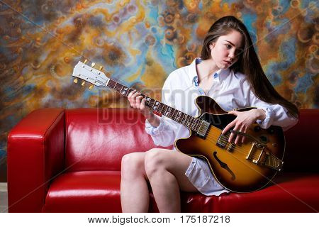 Podolsk, Russia - February 21, 2017: Young brunette girl with a vintage electric guitar Gibson es-345 1969 model year