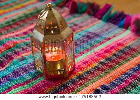 pink candle on a colorful handmade fabric .