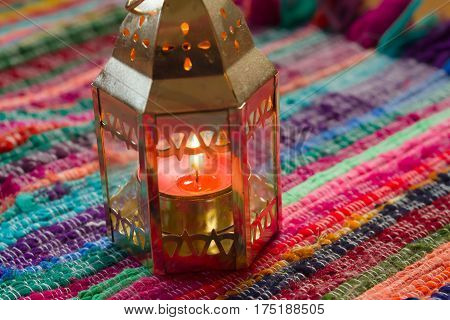 pink candle on a colorful handmade fabric .