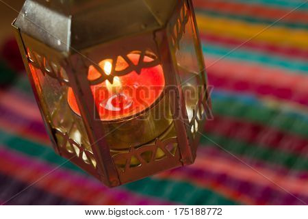 pink candle on a colorful handmade fabric .