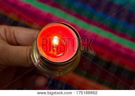 pink candle on a colorful handmade fabric .