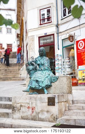 COIMBRA PORTUGAL - September 26 2013: Monument to the singers of the old town the Tricana of Coimbra in the Almedina district of Coimbra. The most popular sculpture of Coimbra is also called Girl with a jug.