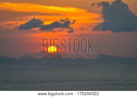 perfect sun hides behind clowds dramatic and colorful sunset at beach