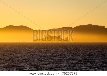 Beautiful view of famous Alcatraz Island illuminated in majestic golden evening light at sunset in summer San Francisco Bay California USA