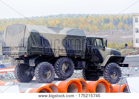 Nizhniy Tagil Russia - September 25. 2013: Army truck URAL-4320 jumps through obstacle on high speed. Display of fighting opportunities of arms and military equipment. Russia Arms Expo