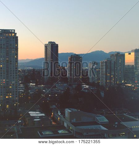 Cityscape And Mountains At Sunset