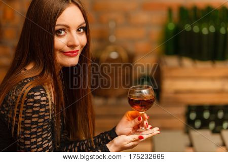 Woman Tasting Wine In Rural Cottage Interior