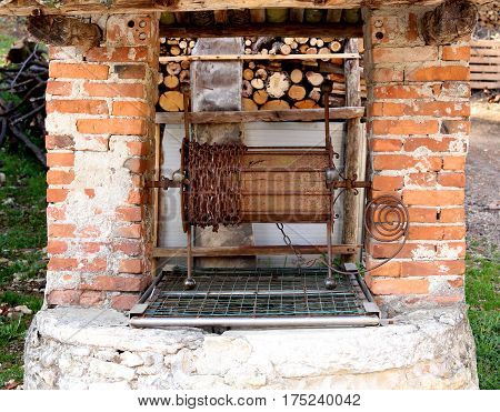 Old Well In Stonework With Rusty Chain To Collect Water With The