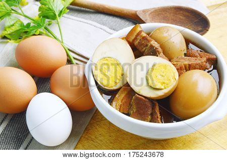 Eggs Stewed or Thai name is khai phalo muu saam chan on wooden background.