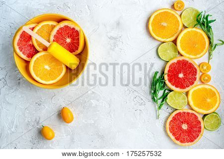 fresh citrus slices with fruit popsicles on stone table background top view mock up