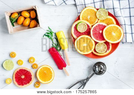 homemade ice-cream with sliced oranges and lime on stone table background top view