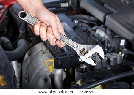 Ruka s klíčem. Mechanik. Auto opravna.