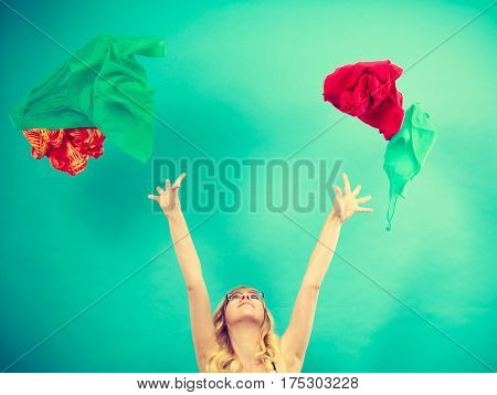 Cleaning in the closet fashion happiness concept. Woman throwing up lot of clothes. Clothing flying all over the place