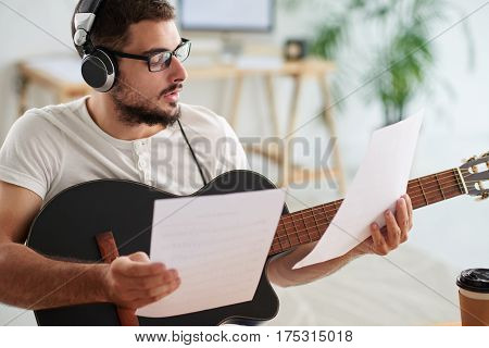 Handsome songwriter in glasses working on new composition
