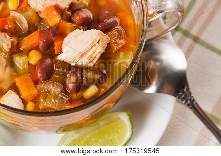 Mexican soup with chicken celery lime bread and vegetables close-up