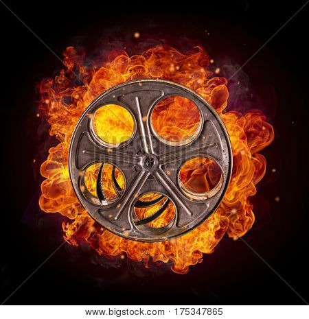Film reel in fire, isolated on black background. Concept of filmmaking.
