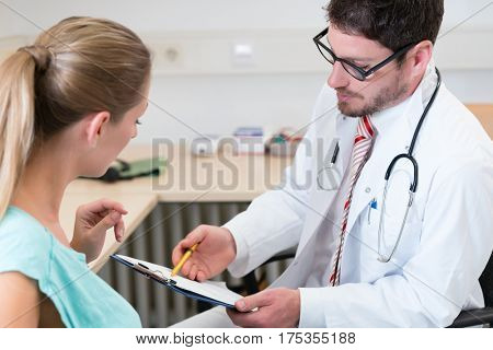 Pregnant woman seeing gynecologist doctor for checkup in his office