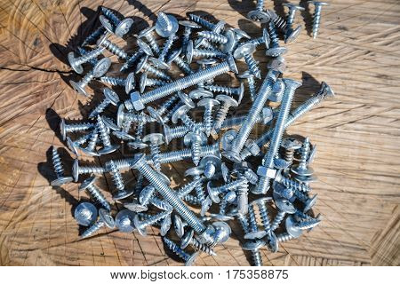 Many Screws On A Wooden Background
