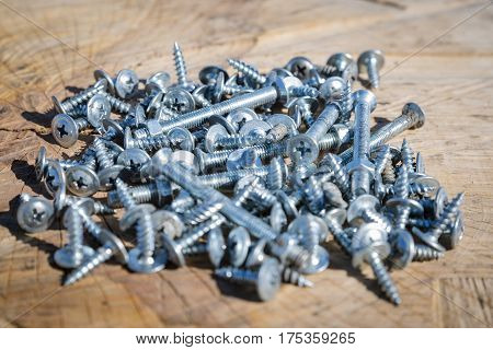 Many Screws On A Wooden Background