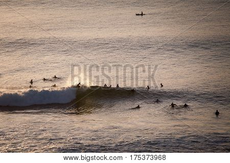 Surfers catch the evening waves in the ocean the view from the top. Bali Indonesia