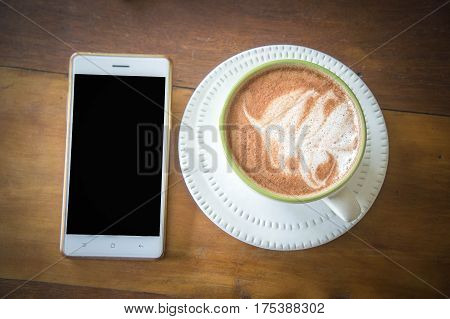 coffee cup and delicious cake strawberry and relax time moblie on table in coffee shop