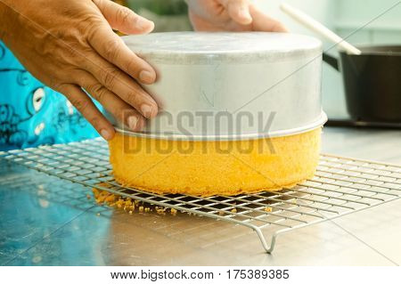 Cook Taking Out Layer Cake From Cake Form