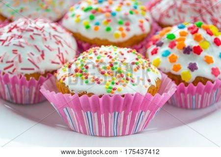 celebrations colored cup cakes with glaze on a plate