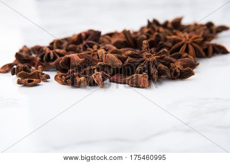 Close up portrait of anise seeds on white marble background