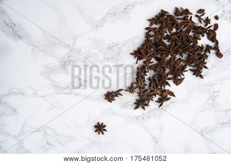 Top view of star anise spice on white marble background