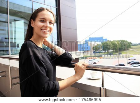 Stylish modern city image of attractive young woman on terrace in sunny morning. Big city life, great success, business, happiness, good luck, positivity