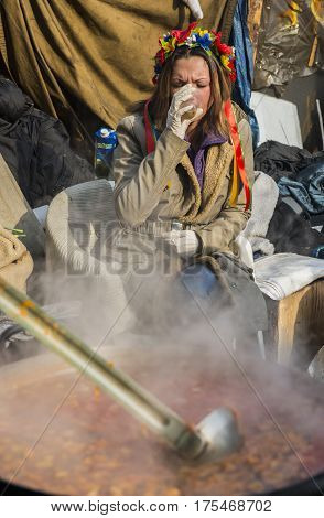 Kiev Ukraine - February 26 2014: Woman drinking in Kiev on Maidan Square during the revolution in the Ukraine.