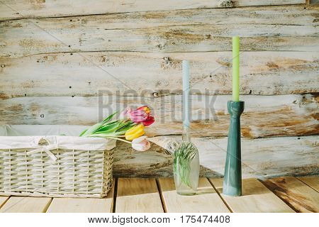 wooden background with flowers and candles in candlestick.