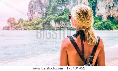 Blond beautiful Women with Sunglasses and Backpack on Raily, Hat Tom Sai Beach, Railay, Krabi.