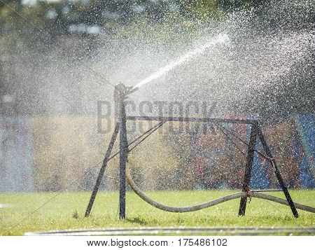 Sprinkler watering the grass of the football field