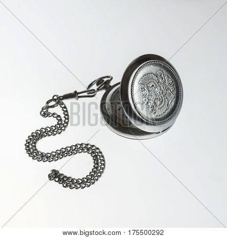 Old pocket watch on a white table
