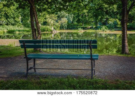 Park bench shaded under the trees in the Halifax Public Gardens, Halifax, Nova Scotia, Canada.