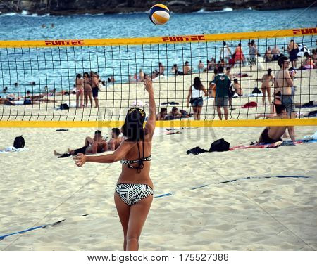 Sydney Australia - Feb 5 2017. Girl in bikini playing beach volleyball on Coogee beach. Women and men having fun. Recreational volley ball game in summer living healthy active sport lifestyle.