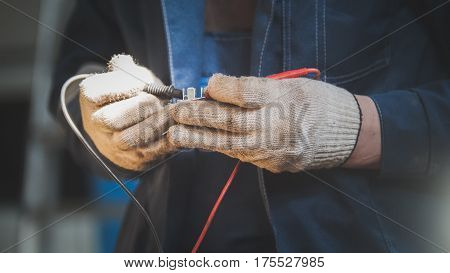 Mechanic works with car electrics - electrical wiring, close up