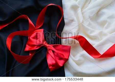 red bow and red silk ribbon on a black and white background